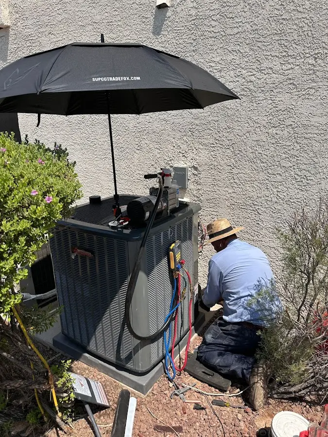 HVAC technician performing outdoor AC maintenance in Rock Springs