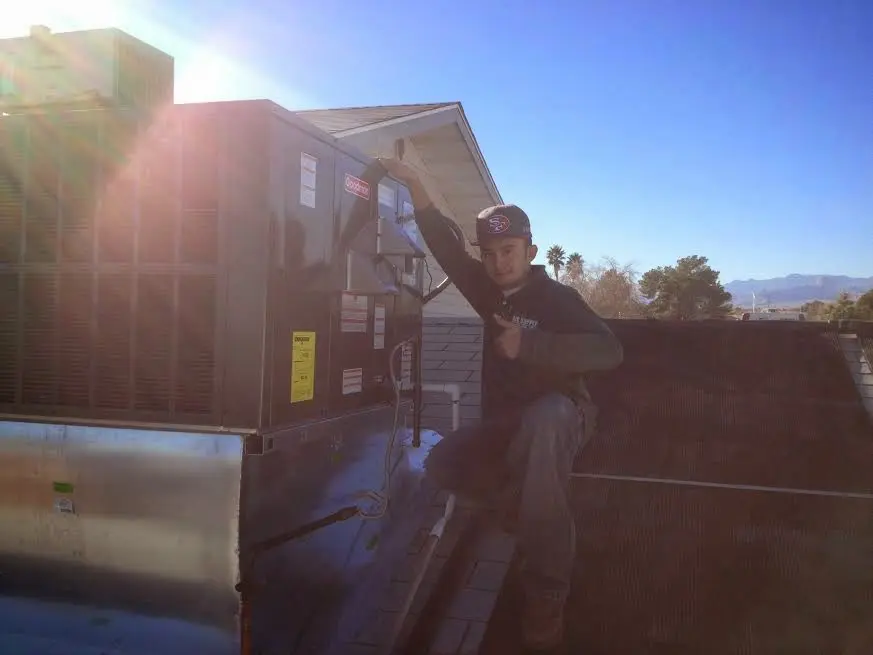 HVAC technician performing Heat Pump Repair on a rooftop unit in Rock Springs
